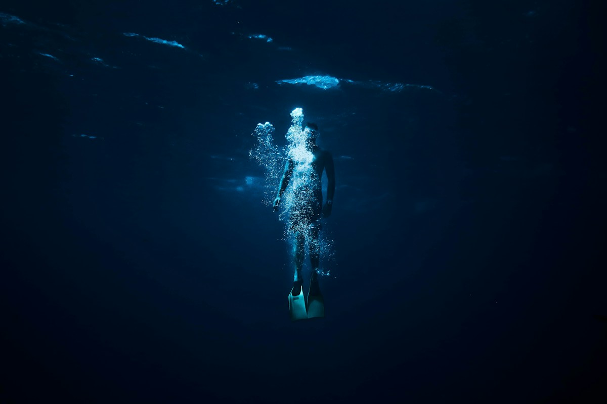 Scuba diver moving through deep blue water
